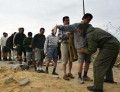 Palestinian workers line up to get checked by a Palestinian security officer in the north Gaza Strip. Palestinian workers line up to get checked by a Palestinian security officer before entering the Israeli controlled industrial zone in Erez area between Israel and the Gaza Strip.