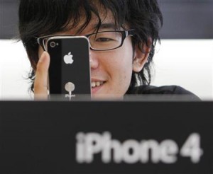 Customer examining an iPhone 4 at an Apple Store in Tokyo's Ginza district