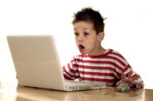 Young child sitting at a computer screen illustrating digital safety concerns